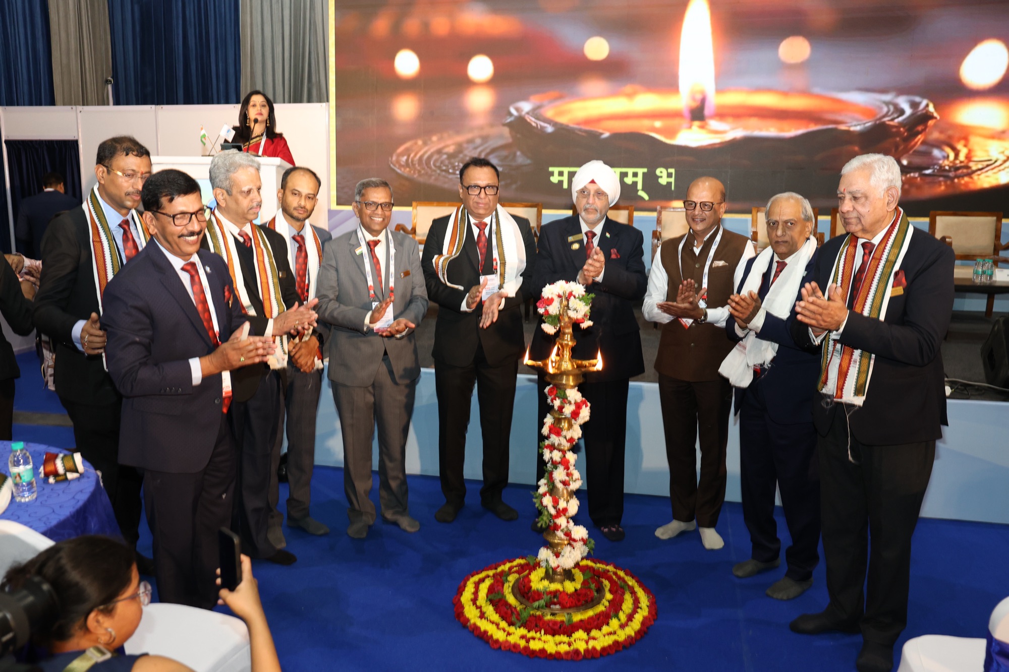 Dignitaries gathered around the ceremonial lamp at PlumbexIndia